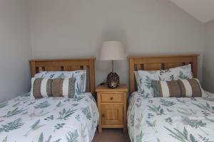 dos camas sentadas una al lado de la otra en un dormitorio en Tullyally's View, en Red Castle