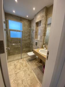 a bathroom with a shower and a toilet and a sink at Hacienda Bay Luxury Chalet هاسيندا باي in El Alamein
