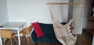 a hammock in a living room with a table and a chair at Private room at Ceausescu's place in Old City Unirii Square in Bucharest