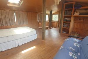 Habitación con cama y estanterías en una cabaña en Remodelada Cabaña Antoleo a metros de Lago Vichuquén, en Vichuquén