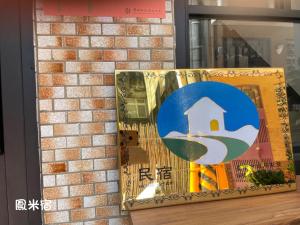 a painting of a house on a brick wall at 鳳米宿Roomi house3 in Tainan
