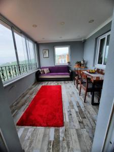 sala de estar con alfombra roja en el suelo en Aktürk villa, en Trabzon