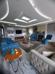 una sala de estar con sofás azules y una mesa. en Aktürk villa, en Trabzon