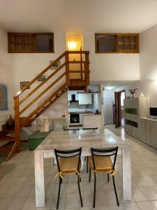 a kitchen with a table and two chairs and a staircase at CASA VACANZE ARBORIAMAR SORSO SARDEGNa in Marina di Sorso