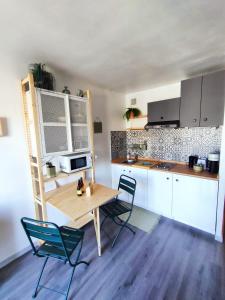 een keuken met een houten tafel en stoelen in een kamer bij Appart cocooning proche centre avec Parking in Hyères