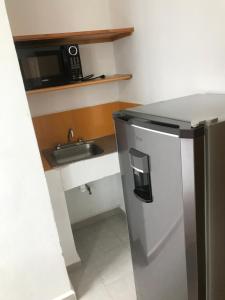 a small kitchen with a stainless steel refrigerator and a sink at Casa Caracol Guanajuato in Guanajuato