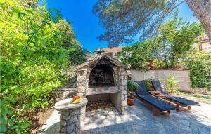 a patio with a stone fireplace and two chairs at Holiday Home Jadrija Vii Iii in Jadrija