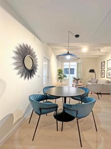 加的斯Apartamentos Soho Boutique Palillero的一间带桌子和蓝色椅子的用餐室 更多12张照片
