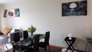 a living room with a dining room table with a vase of flowers at Menlyn Bizcation Accommodation in Pretoria