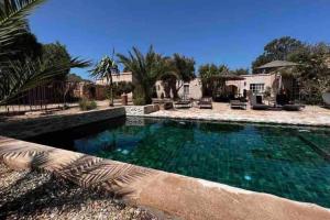 a swimming pool in front of a house at Villa Oleya Belle demeure nature in Essaouira