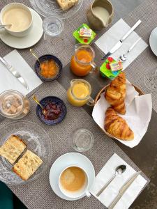 einen Tisch mit einem Haufen Frühstückslebensmittel und Kaffee in der Unterkunft VILLA RASOA chambre LIBELLULE in Cap d'Agde