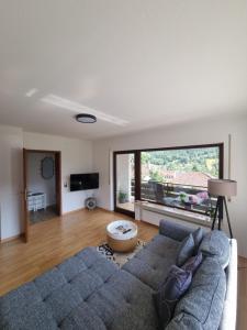 uma sala de estar com um sofá e uma grande janela em Miu's Ferienwohnung em Alpirsbach