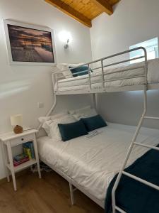a bedroom with two bunk beds and a table at Monte da Caldeirinha in Luz de Tavira