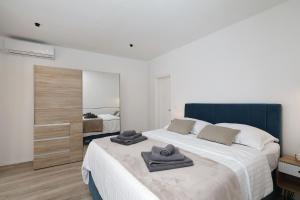 - une chambre avec un grand lit et des serviettes dans l'établissement Villa Dobrila, à Sukošan