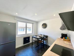 eine Küche mit einer Theke, einem Tisch und einem Fenster in der Unterkunft Le petit cocon Alsacien in Wasselonne