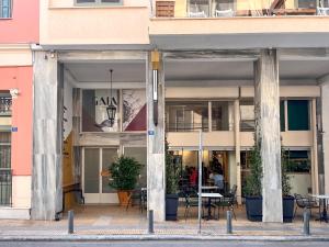 a building with tables and chairs in front of it at Gaia Athens in Athens