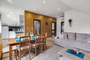 una cucina e un soggiorno con tavolo e divano di Deluxe Apartment with Jacuzzi PATAR a Rakovica