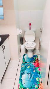 a bathroom with a toilet with a fish rug on the floor at Menlyn Bizcation Accommodation in Pretoria