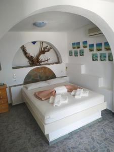 a bedroom with a large white bed with an arch at Lucas B Panorama in Alopronia
