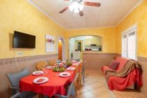 un comedor con una mesa larga con mantel rojo en Villa Rural Piscina fortuna luxury23 personas 10 Habitaciones habitaciones wifi, en Fortuna