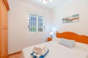 Un dormitorio blanco con una cama con toallas. en Villa Rural Piscina fortuna luxury23 personas 10 Habitaciones habitaciones wifi, en Fortuna