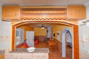 una cocina y una sala de estar con un arco en una casa en Villa Rural Piscina fortuna luxury23 personas 10 Habitaciones habitaciones wifi, en Fortuna