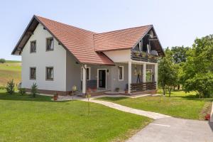 a white house with a red roof at Deluxe Apartment with Jacuzzi - PATAR in Rakovica