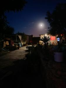 luna llena elevándose sobre un patio por la noche en Cala Creta, en Lampedusa