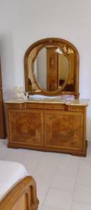 a wooden dresser with a mirror on top of it at Villa Bellino in Castellana Grotte