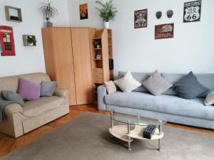 a living room with two couches and a glass coffee table at A jump from downtown in Budapest