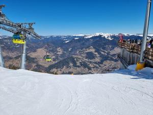 a ski lift with people on a snow covered mountain at Vila Bijou in Borşa