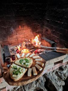 a wooden board with bread and cheese in front of a fireplace at Cabana Dor de Apuseni in Cîmpeni