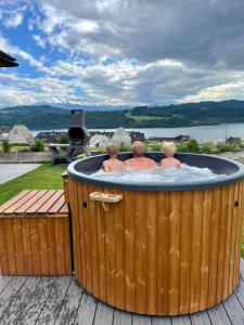 three people in a jacuzzi in a hot tub at Chata Stylchyn in Kluszkowce