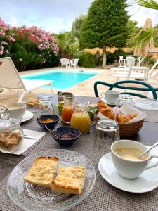 una mesa con desayuno de pan y tostadas en VILLA RASOA chambre LOVE, en Cap d'Agde