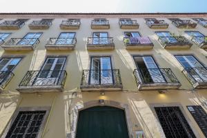 a tall building with balconies and a door at LR Guest House in Lisbon