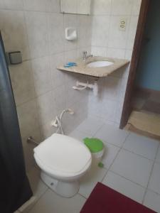 a bathroom with a white toilet and a sink at Pousada Caminho in Serra do Cipo