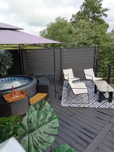 a deck with a hot tub and chairs and a table at The POD Unique & Stylish Luxury Accommodation With Hot Tub in Swanlinbar