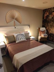 ein Schlafzimmer mit einem großen Bett und einem Stuhl in der Unterkunft Center Flat Puerto Del Carmen near the Beach NATURAL ELEMENTS APARTMENT in Puerto del Carmen