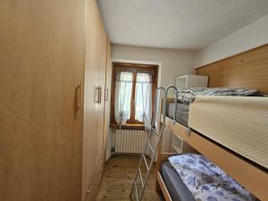 a small room with two bunk beds and a window at THE YELLOW HOUSE in Bormio