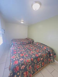 a bed with a floral comforter in a bedroom at Shore Beach Houses - 40 - 1 Dupont Ave in Seaside Heights