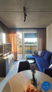 a living room with a blue couch and a table at Nyskie Ustronie in Nysa