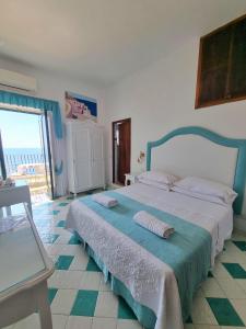 sypialnia z dużym łóżkiem i dużym oknem w obiekcie Pensione Maria Luisa w mieście Positano