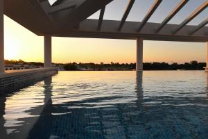 a swimming pool with the sunset in the background at Puerta Salina Isla Cristina in Isla Cristina +14 photos