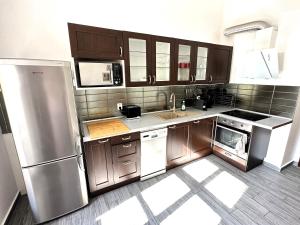 een keuken met houten kasten en een roestvrijstalen koelkast bij Black Eagle Apartments in Praag