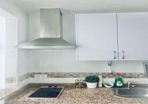 a kitchen with white cabinets and a sink at Lovely studio at the city heart! in Málaga