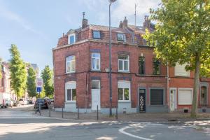 un edificio de ladrillo rojo en la esquina de una calle en Cosy house 10P - 5 chambres -5 salles de bain - proche Lille et toutes commodités, en Roubaix