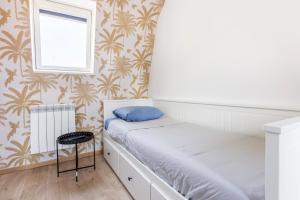 Habitación pequeña con cama y ventana en Cosy house 10P - 5 chambres -5 salles de bain - proche Lille et toutes commodités, en Roubaix