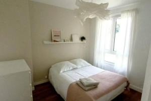 - une petite chambre avec un lit et une fenêtre dans l'établissement Maisonnette Au 15, à Auxerre