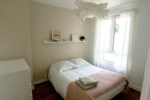 a small bedroom with a bed and a window at Maisonnette Au 15 in Auxerre