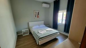 a small bedroom with a bed and a window at Cozy villa, Golem beach. in Golem